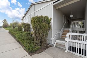 Newport apartment for rent - A white building with a porch and a sign on the side.