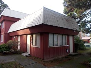 Port Orford apartment for rent - A red house with a grey roof and a white door.
