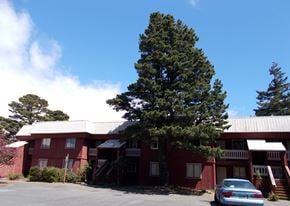 Port Orford apartment for rent - A red building with a tree in front of it.