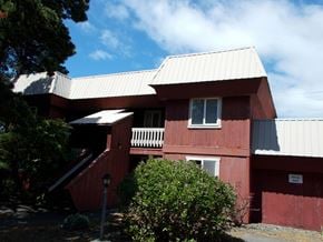 Port Orford apartment for rent - A red building with a white roof and a sign on the side.