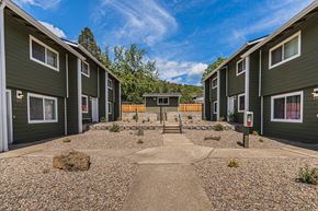 Gold Hill apartment for rent - a courtyard between two green houses with a blue sky in the background