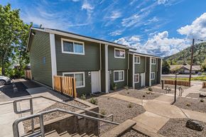 Gold Hill apartment for rent - a green building with stairs and a yard in front of it