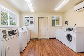 Rogue River apartment for rent - an empty laundry room with washes and dryers and a door to a room