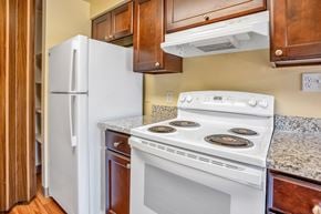 Talent apartment for rent - a kitchen with a white stove and a refrigerator