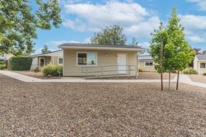 Talent apartment for rent - a small tan house with a gravel driveway and trees