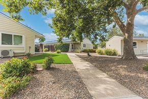Talent apartment for rent - a walkway between two houses with trees and a sidewalk