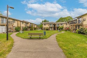 Winston apartment for rent - a park with a bench in front of some apartment buildings