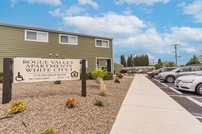 White City apartment for rent - A sign for Rogue Valley Apartments in White City stands in front of a building.