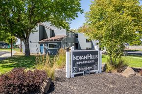 Pendleton apartment for rent - A sign for Indian Hills Apartments is in front of a building.