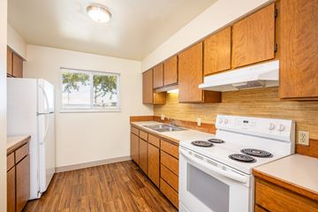 Pendleton apartment for rent - A kitchen with wooden cabinets and a white stove top oven.