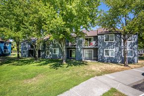 Pendleton apartment for rent - A row of houses with green trees in front.
