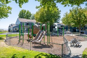 Pendleton apartment for rent - A playground with a slide, swings, and a picnic table.