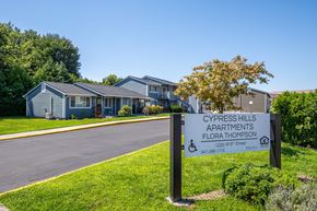 The Dalles apartment for rent - A sign for Cypress Hills Apartments stands in the grass by a road.