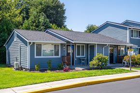 The Dalles apartment for rent - A blue house with a yellow caution sign in front.