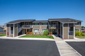 The Dalles apartment for rent - A modern two-story apartment building with a parking lot in front.