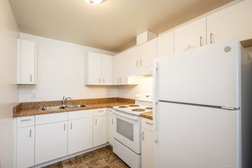 The Dalles apartment for rent - A kitchen with white appliances and cabinets.