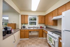 Cottage Grove apartment for rent - a kitchen with wooden cabinets and a white stove and refrigerator