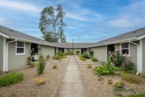 Cottage Grove apartment for rent - a row of houses with a sidewalk and plants in the yard