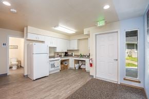 Lincoln City apartment for rent - A kitchen with a white fridge and a white door.