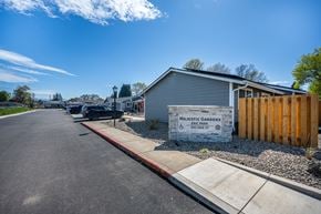 Junction City apartment for rent - A sign for Majestic Gardens sits in front of a grey building.