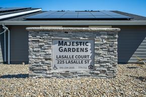 Harrisburg apartment for rent - Majestic Gardens sign in front of a house with solar panels.