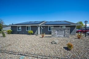 Harrisburg apartment for rent - A house with solar panels on the roof and a sign that says "Majestic Gardens".
