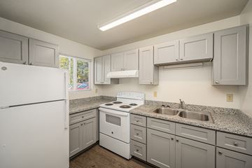 Veneta apartment for rent - A kitchen with white appliances and cabinets.