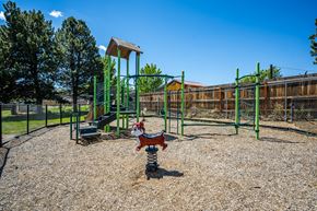 Redmond apartment for rent - A playground with a green swing set and a red slide.