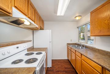 Bend apartment for rent - A kitchen with a white stove and wooden cabinets.