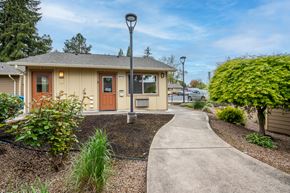 Salem apartment for rent - a walkway leading to a small yellow house with a sidewalk