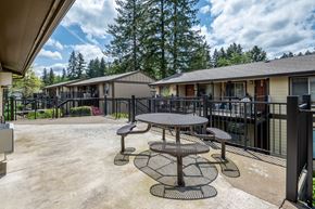 Estacada apartment for rent - a patio with a table and chairs in front of a building