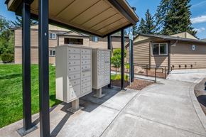 Sandy apartment for rent - an old mailboxes on a sidewalk in front of a house