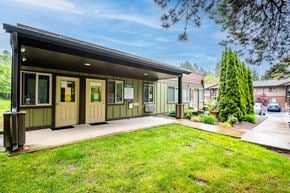 Sherwood apartment for rent - the front of a green house with a lawn and a driveway