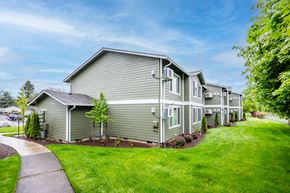 Mcminnville apartment for rent - a gray house with green grass and trees next to a sidewalk