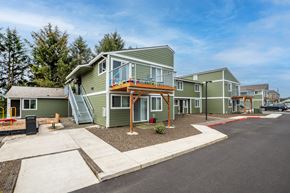 Tillamook apartment for rent - a row of green manufactured homes with a porch and stairs