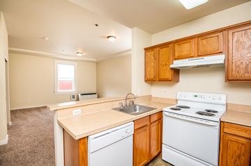The Dalles apartment for rent - a kitchen with white appliances and wooden cabinets