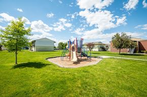 Hermiston apartment for rent - a playground with a swing set in the middle of a yard