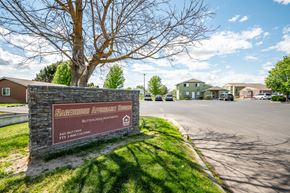 Hermiston apartment for rent - a brick sign sits on the side of a road in front of some houses