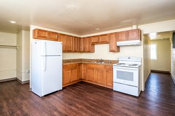 Milton-Freewater apartment for rent - an empty kitchen with white appliances and wooden cabinets