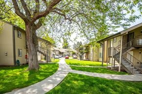 Milton-Freewater apartment for rent - a pathway between two buildings with trees and green grass