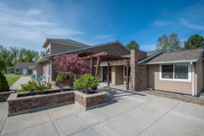 Baker City apartment for rent - the view of a house with a concrete driveway and a landscaped yard