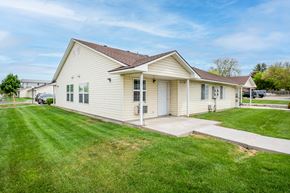 Ontario apartment for rent - the front of a white house with a lawn and a driveway