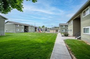 Ontario apartment for rent - the view of a yard between two rows of houses with grass