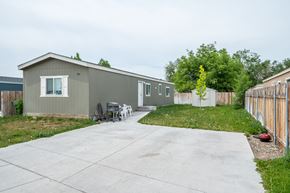 Ontario apartment for rent - a gray house with a driveway and a yard with a fence