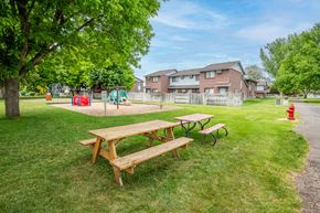 Fruitland apartment for rent - a park with picnic tables and a playground in front of a house