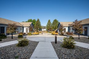 Wallowa apartment for rent - A courtyard surrounded by buildings with a clear blue sky above.