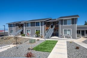 Gold Beach apartment for rent - A row of houses with grey siding and white trim.