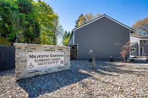 Veneta apartment for rent - Majestic Gardens Sunburst Manor is a residential building with a sign in front.