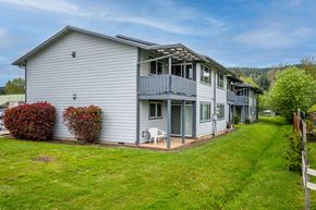 Sutherlin apartment for rent - A grey house with a white chair in front of it.