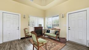 Tombstone apartment for rent - A living room with a fireplace and two chairs.